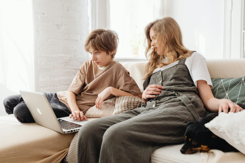 a couple of kids sitting on a couch with a laptop, pexels, mama i need wife, casual clothing, profile image, brown