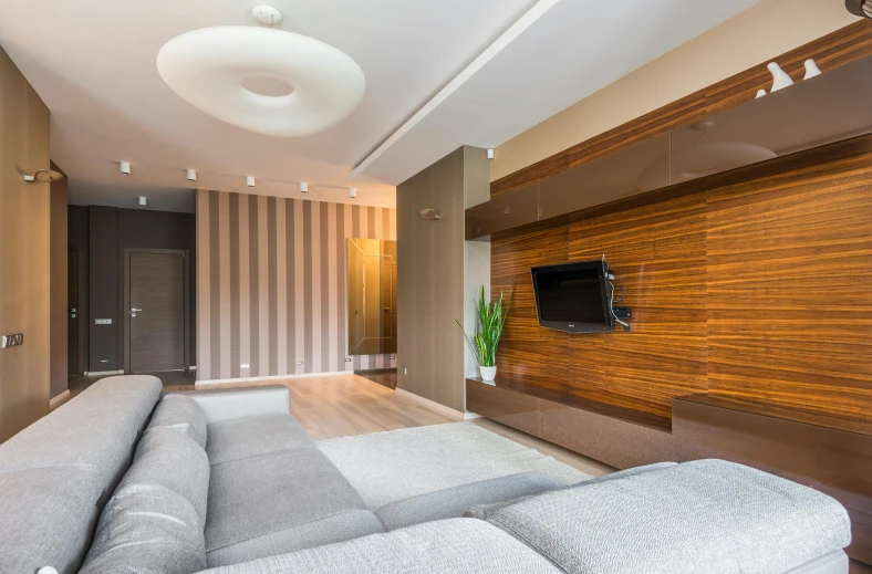 a large gray couch sitting in front of a flat screen tv