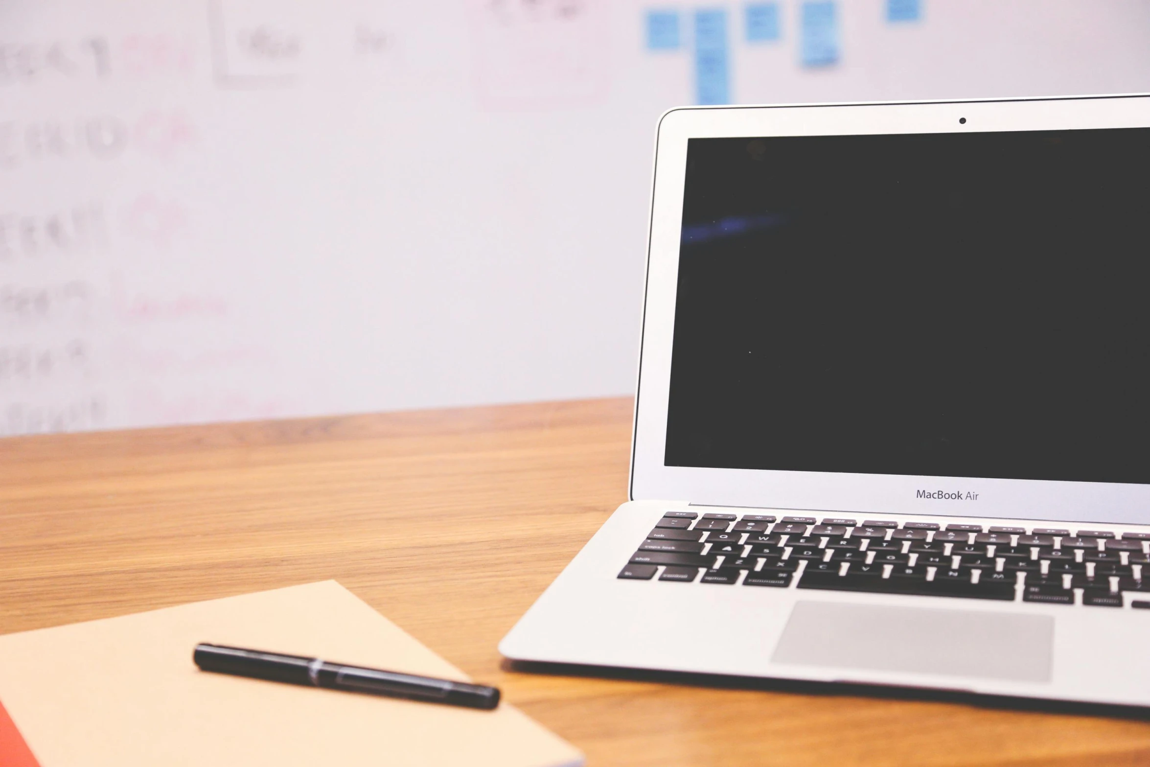 a laptop computer sitting on top of a wooden desk, pexels, whiteboards, background image, rich evans, 555400831