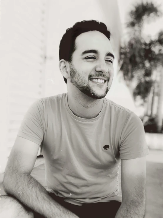 a black and white photo of a man sitting on a skateboard, inspired by Camilo Egas, headshot profile picture, smiling sweetly, charlie cox, sayem reza