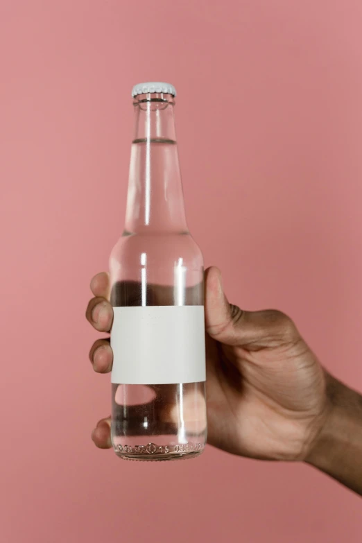 a person holding a bottle of water against a pink background, an album cover, by Jacob Toorenvliet, pexels, no - text no - logo, made of drink, detailed product image, semi-transparent