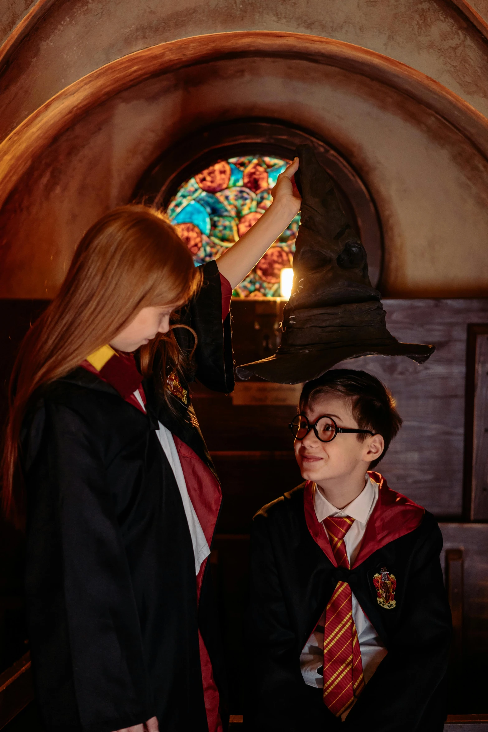 a couple of people standing next to each other, hogwarts gryffindor common room, for junior, studio lit, up close