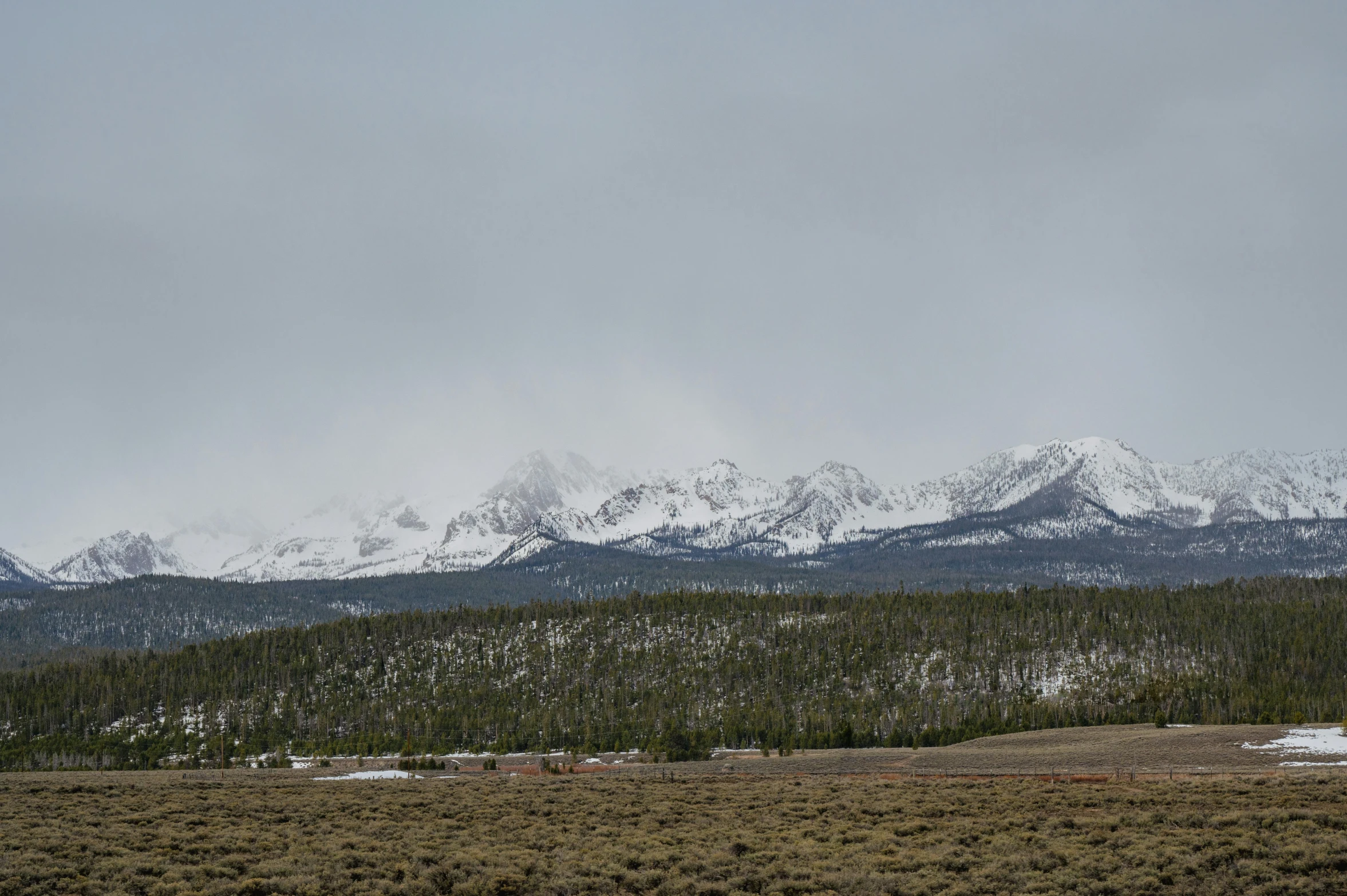 an alpine landscape with snow covered mountains in the background