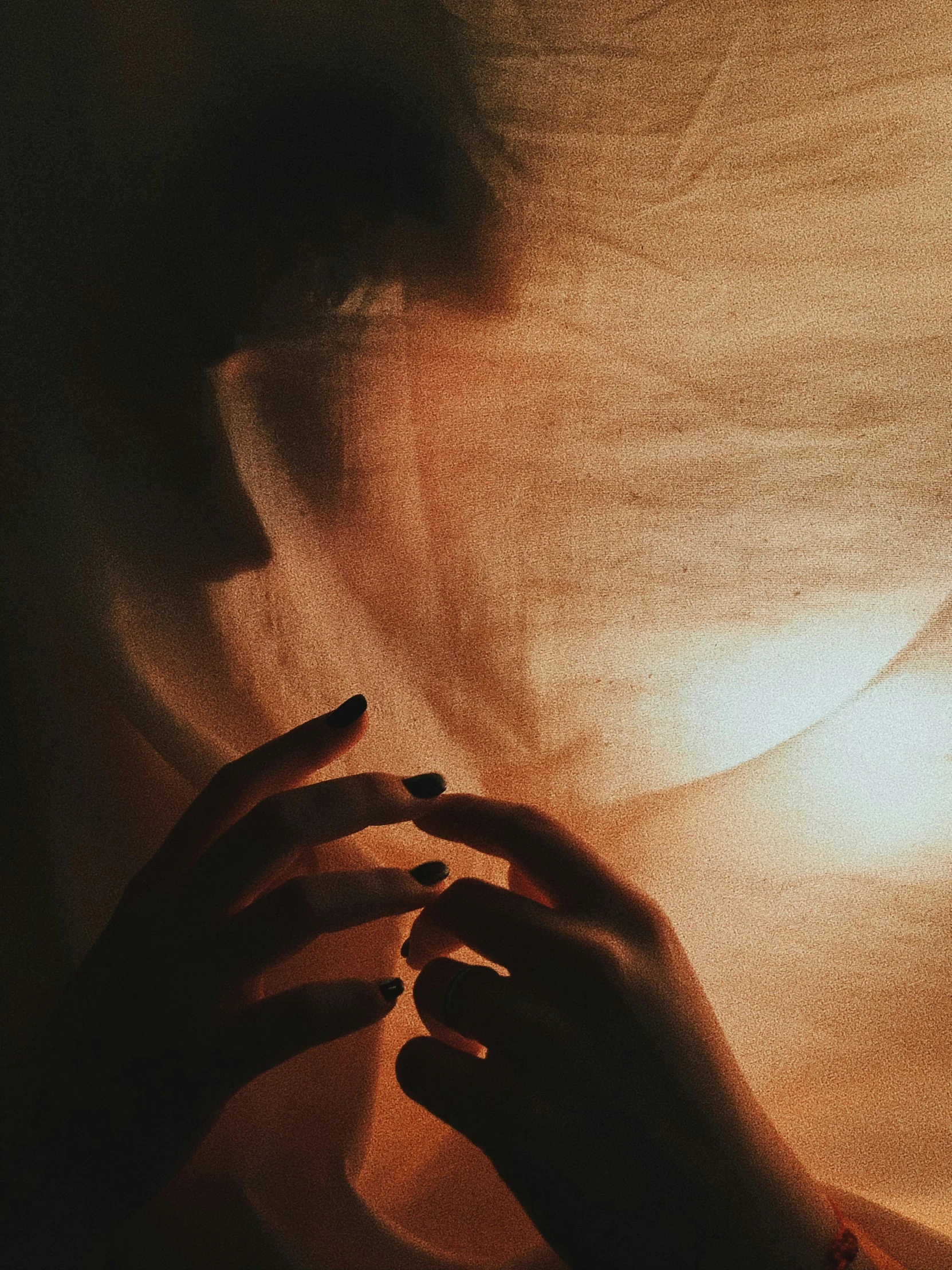 a person covering their face with a sheet, an album cover, inspired by Elsa Bleda, pexels contest winner, romanticism, orange light, sophisticated hands // noir, dark and beige atmosphere, ☁🌪🌙👩🏾