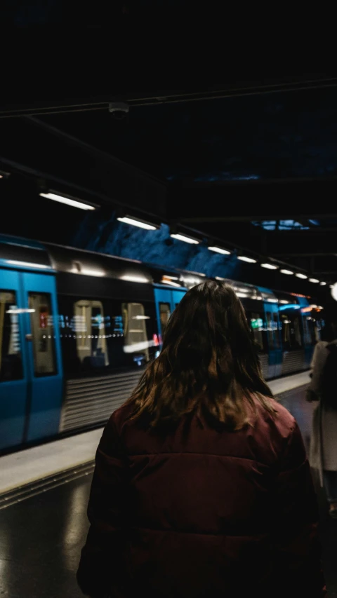 a train pulls into a dark platform at a subway station