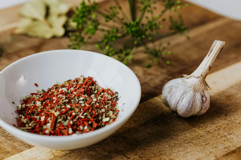 a white bowl sitting on top of a wooden cutting board, trending on pexels, renaissance, spices, garlic on background, red meat shreds, background image