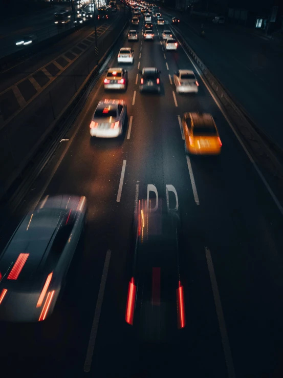 a highway with many cars on it is shown at night