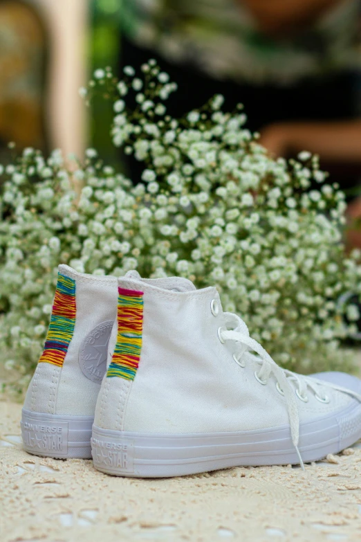 a pair of white sneakers sitting on top of a table, inspired by Okuda Gensō, macrame, wedding, midsommar color theme, tall