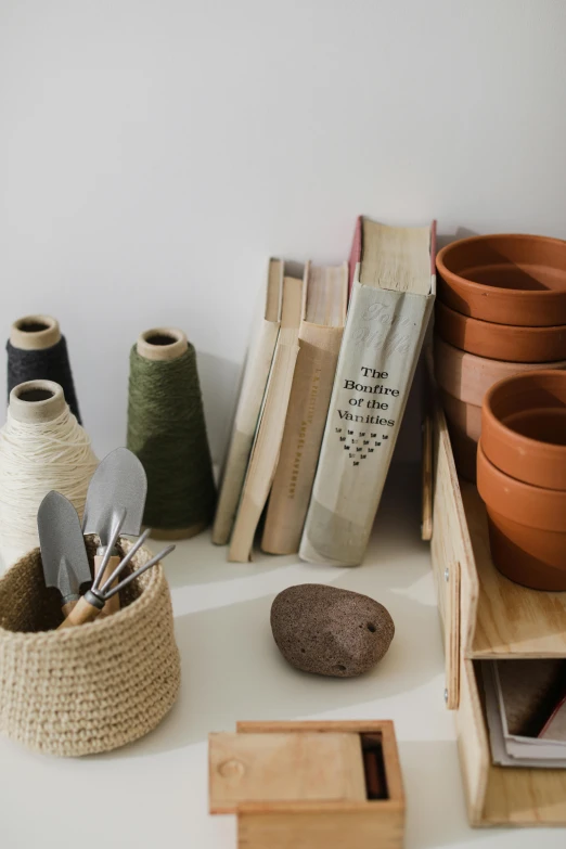 a bunch of pots sitting on top of a table, a still life, by Jessie Algie, trending on unsplash, short bookshelf, natural materials, close-up product photo, with a bunch of stuff