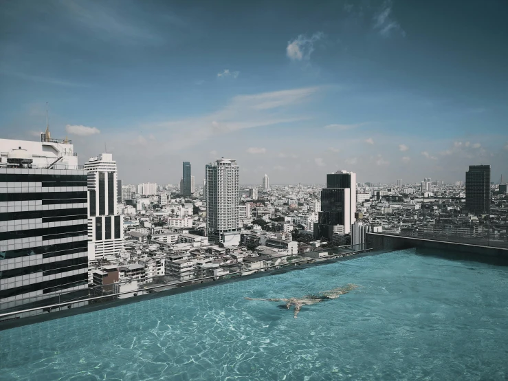 a person swimming in a pool on top of a building, bangkok, desktop wallpaper, square, jen atkin