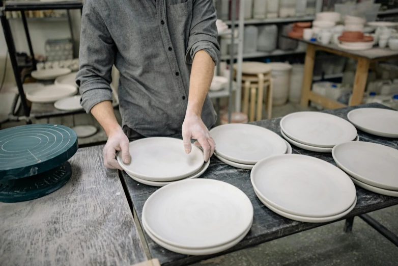 a man that is standing over some plates, process art, professional product photo, moonlight grey, white clay, pristine and clean