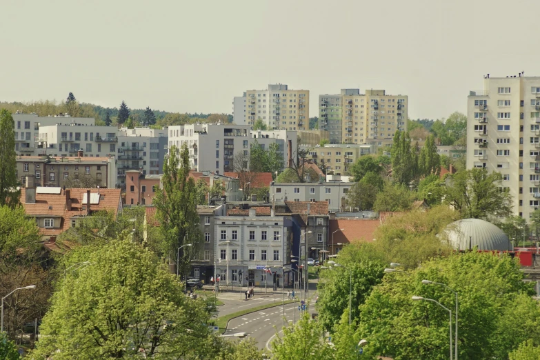 a view of a city from the top of a hill, a photo, by Adam Marczyński, unsplash, bauhaus, eldenring, against the backdrop of trees, 2000s photo, slide show