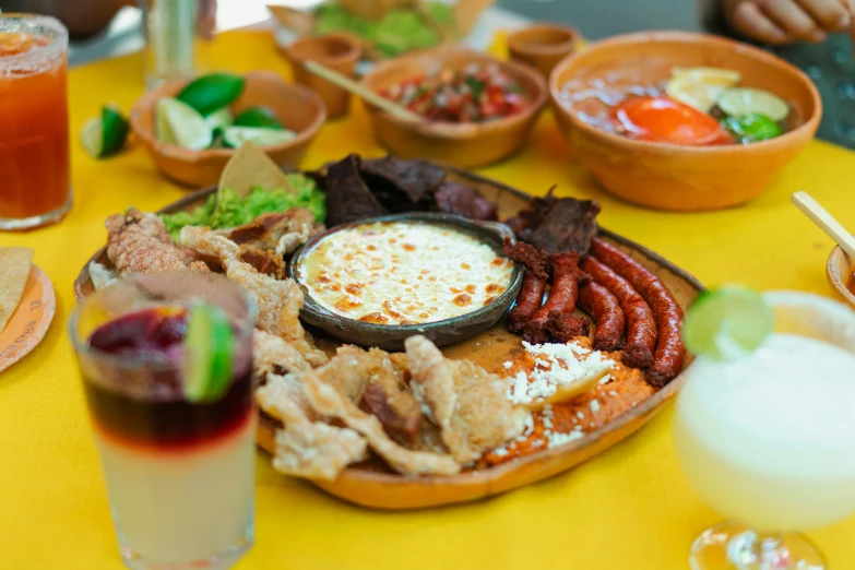 a plate full of meat and vegetables with a glass of beer on the table