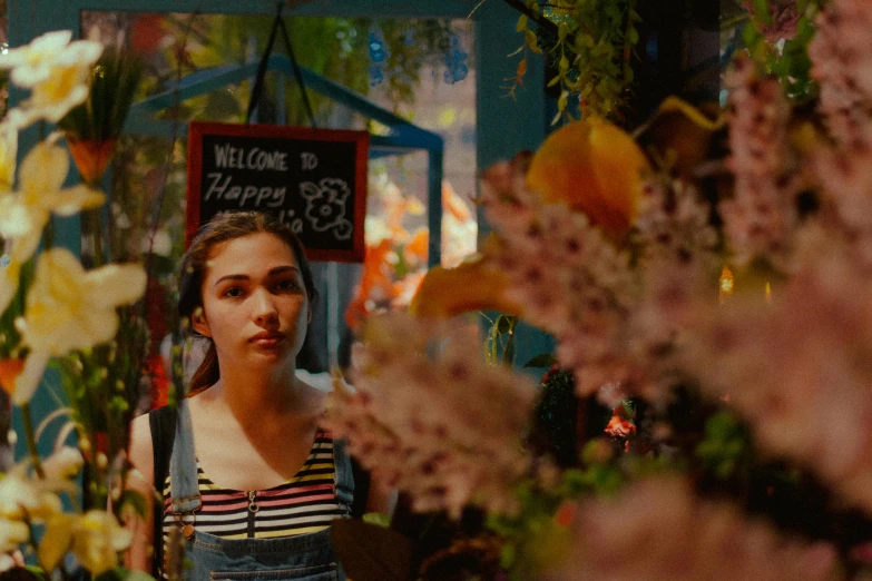 a woman standing in front of some flowers