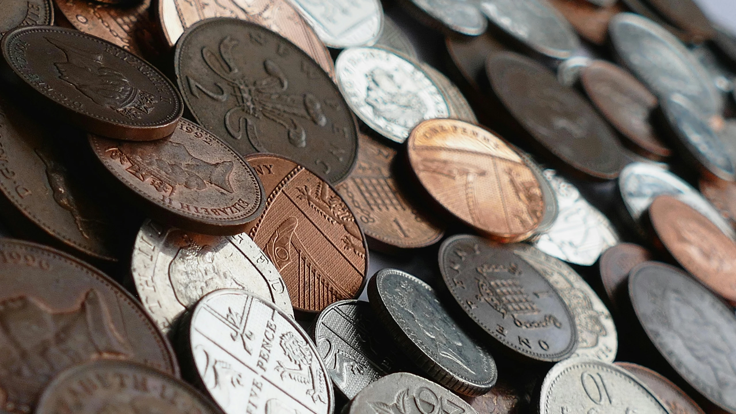 a pile of coins sitting on top of a table, a screenshot, by Alison Watt, pexels, 🦩🪐🐞👩🏻🦳, middle close up, promo image, britain