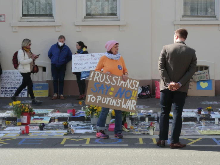 a group of people standing in front of a building, placards, war in ukraine, wellington, sanctions in russia