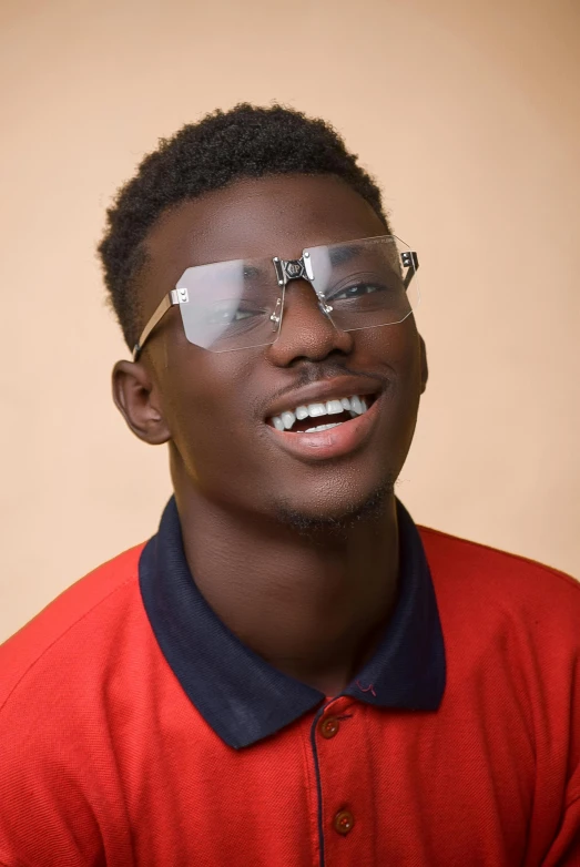 a black man wearing glasses is smiling and posing for the camera