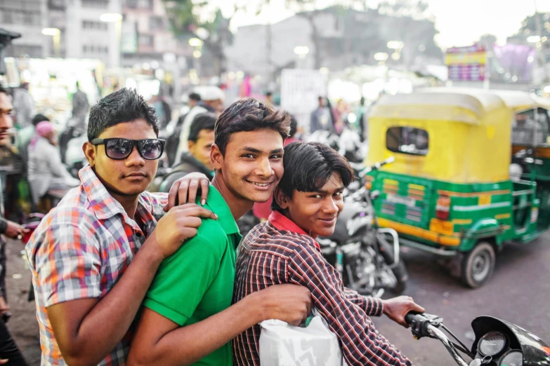 a group of men riding on the back of a motorcycle, by Meredith Dillman, pexels contest winner, on an indian street, cute boys, avatar image, smiling