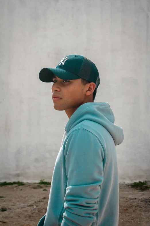 a man standing in the dirt with a baseball cap on