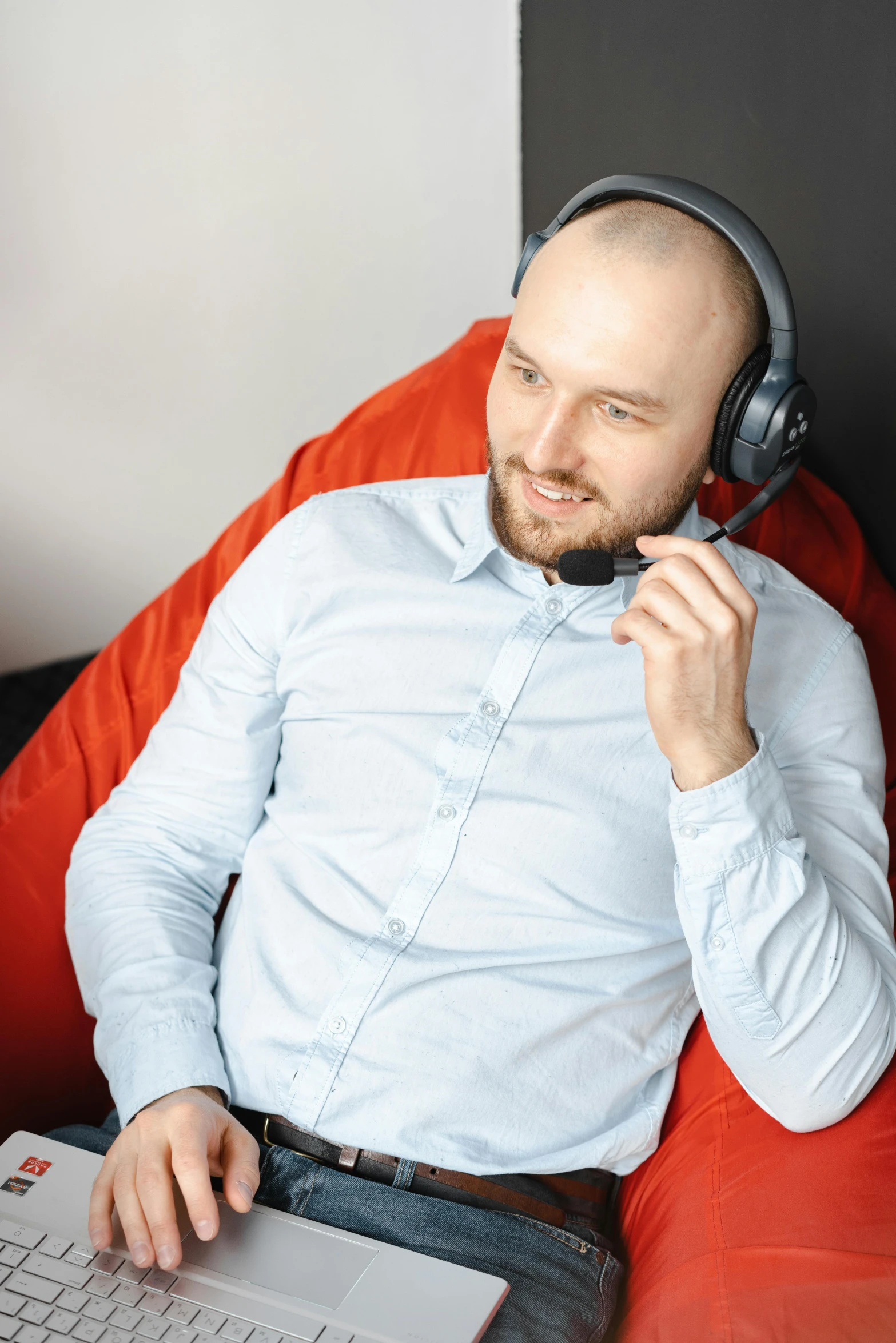 a man sitting in a chair with a laptop and headphones, agent pekka, it specialist, thumbnail, bald