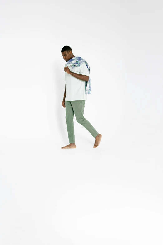 a man holding a baby in his arms, an album cover, trending on unsplash, happening, olive green slacks, dynamic pose full body, gradient pastel green, in front of white back drop