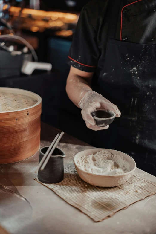 a chef preparing food in a restaurant kitchen, a portrait, inspired by Gu An, trending on pexels, covered in white flour, made of smooth black goo, wooden bowl, pick wu