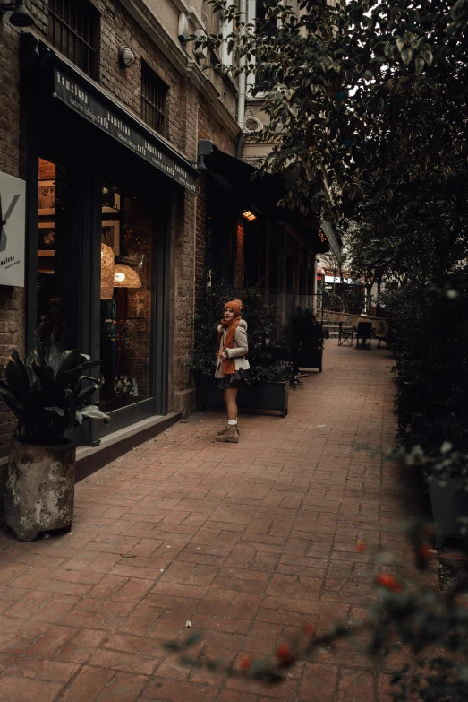 little girl walking on a brick sidewalk in front of a store