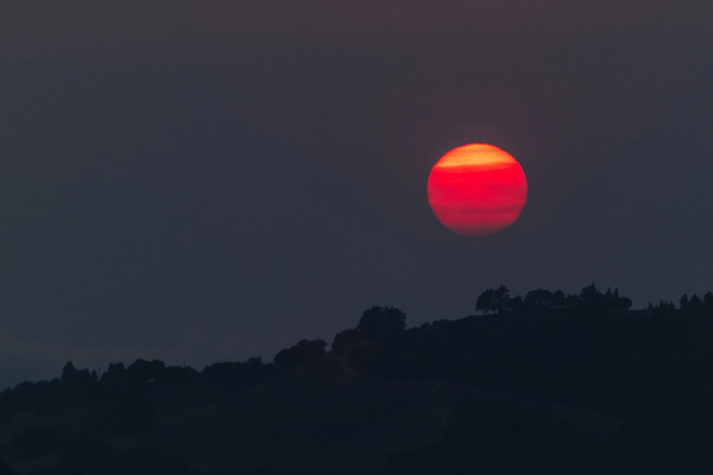 the sun is setting on top of a mountain, a picture, by Alessandro Allori, red moon, hazy, uncropped, low iso