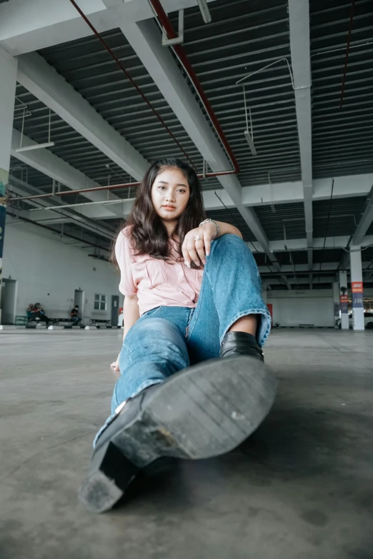 a woman sitting on top of a black skateboard