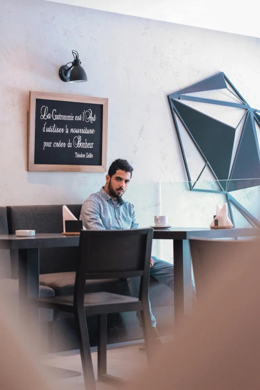 a man sitting in a booth using a laptop