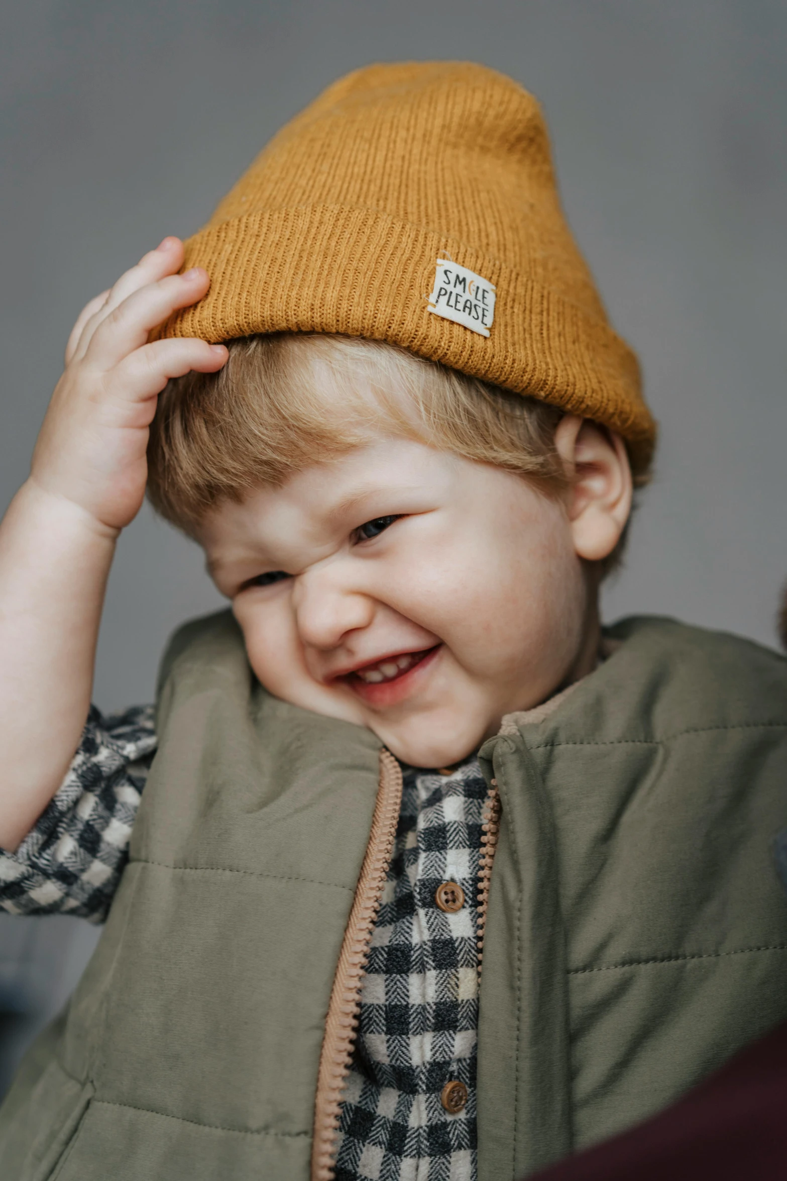 a close up of a child wearing a hat, curated collections, smiling male, warm color clothes, small crown