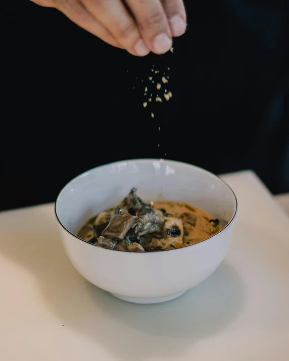 a close up of a bowl of food on a table, pexels contest winner, process art, spores, baking cookies, quokka, licorice allsort filling