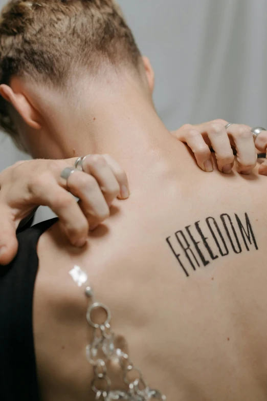 a woman that has a tattoo on her back, trending on pexels, symbolism, freedom fighter, a labeled, gay rights, recovering from pain