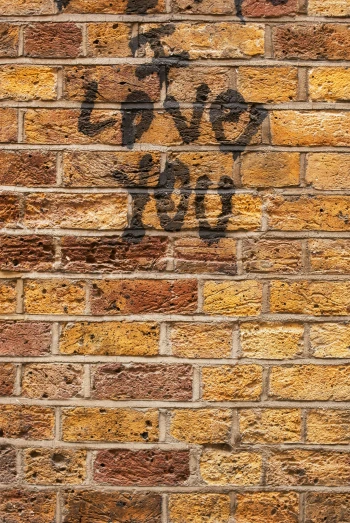a graffiti sign is painted on the side of a brick wall
