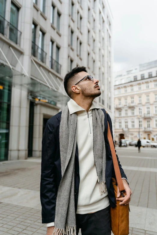 man holding a brown bag while standing next to tall buildings