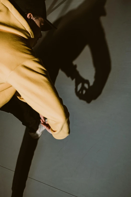 a man riding a skateboard up the side of a ramp, inspired by Georges de La Tour, trending on unsplash, visual art, dramatic shadow, yellow clothes, hand on table, two arms that have sharp claws