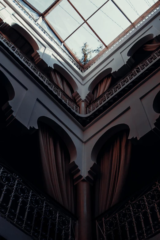 the ceiling in a building with windows and curtains