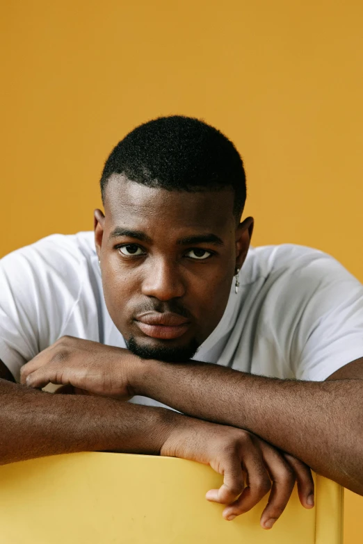 a man leans over a chair to pose for a portrait