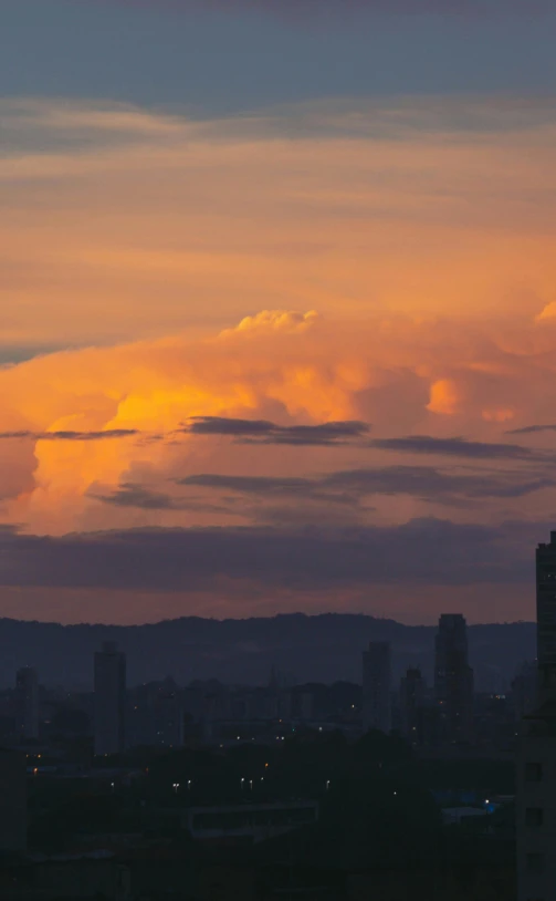 a large clock tower towering over a city, by Fernando Gerassi, pexels contest winner, dramatic storm sunset, alvaro siza, colombia, panorama