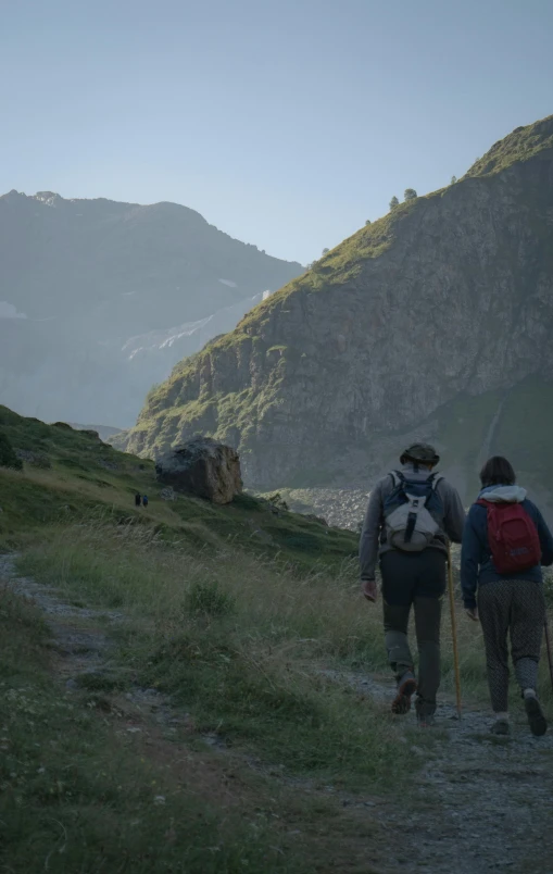 a couple of people that are walking up a hill, by Werner Andermatt, les nabis, 8 k cinematic, early morning, [ cinematic, alp