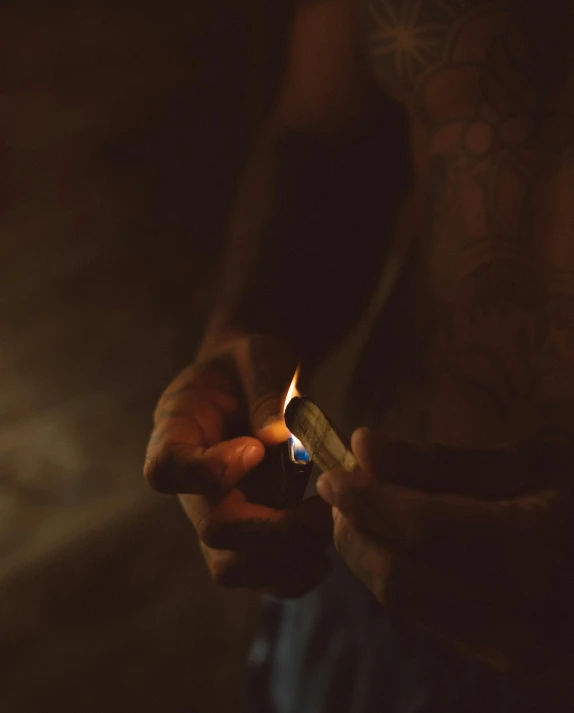 a person holding a lit cigarette lighter with his right hand