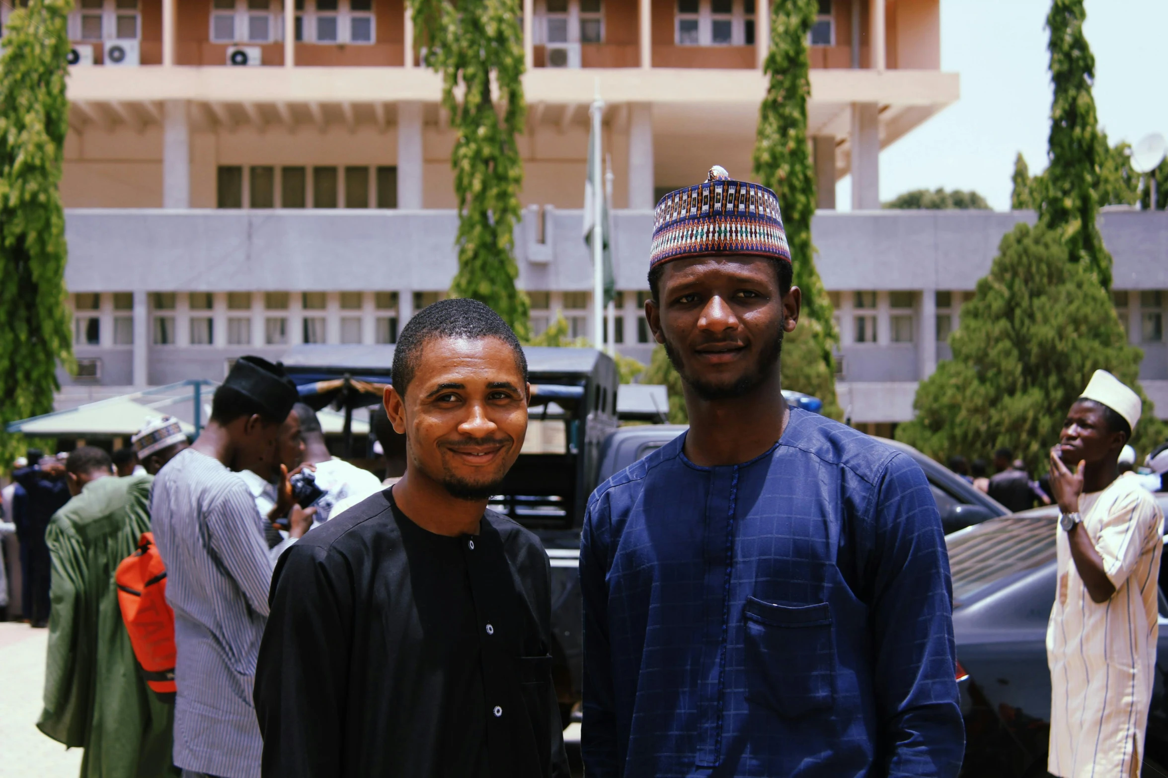 two men smile for a po together at an outdoor event