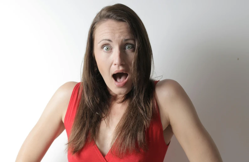 a woman in a red dress making a surprised face, pexels contest winner, wearing red tank top, screamer, ultra realistic, mid - 3 0 s