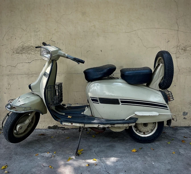 a motor scooter parked in front of a wall, an album cover, unsplash, photorealism, antique, 2 5 6 x 2 5 6, automobile, photo taken in 2 0 2 0