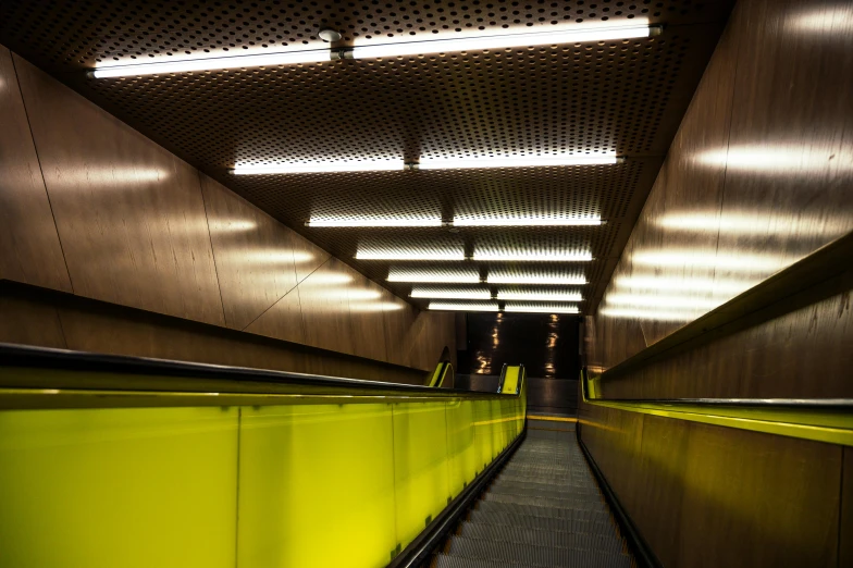 an escalator in a subway station at night, inspired by Andreas Gursky, unsplash, bauhaus, yellow, volumetric lighting”, hyperrealistic ”