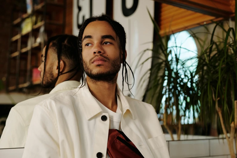 a man with dreadlocks sitting on a bench, trending on pexels, zoë kravitz, wearing a linen shirt, reflection, portrait image