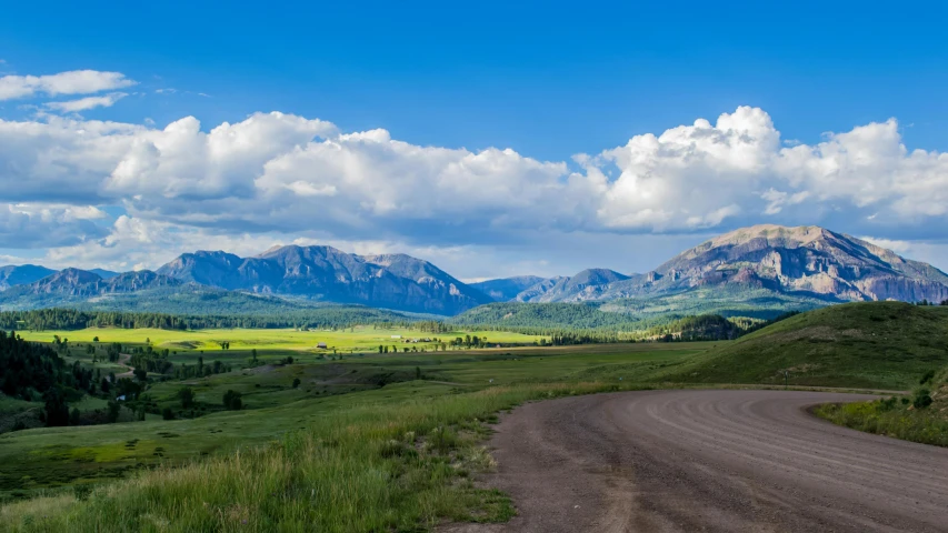 a dirt road with mountains in the background, by Emma Lampert Cooper, pexels contest winner, colorado, panorama, a green, slide show