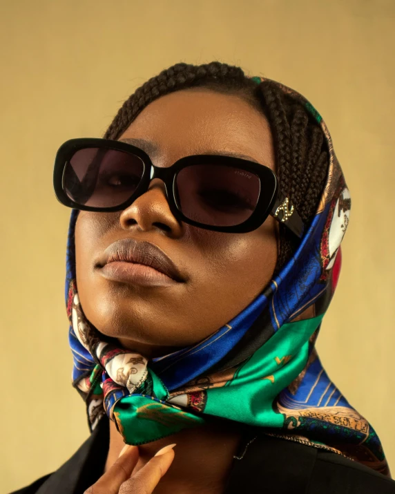 a woman wearing sunglasses and a scarf, an album cover, inspired by Ras Akyem, trending on pexels, lgbtq, gaze down, alexis franklin, trending on bbwchan