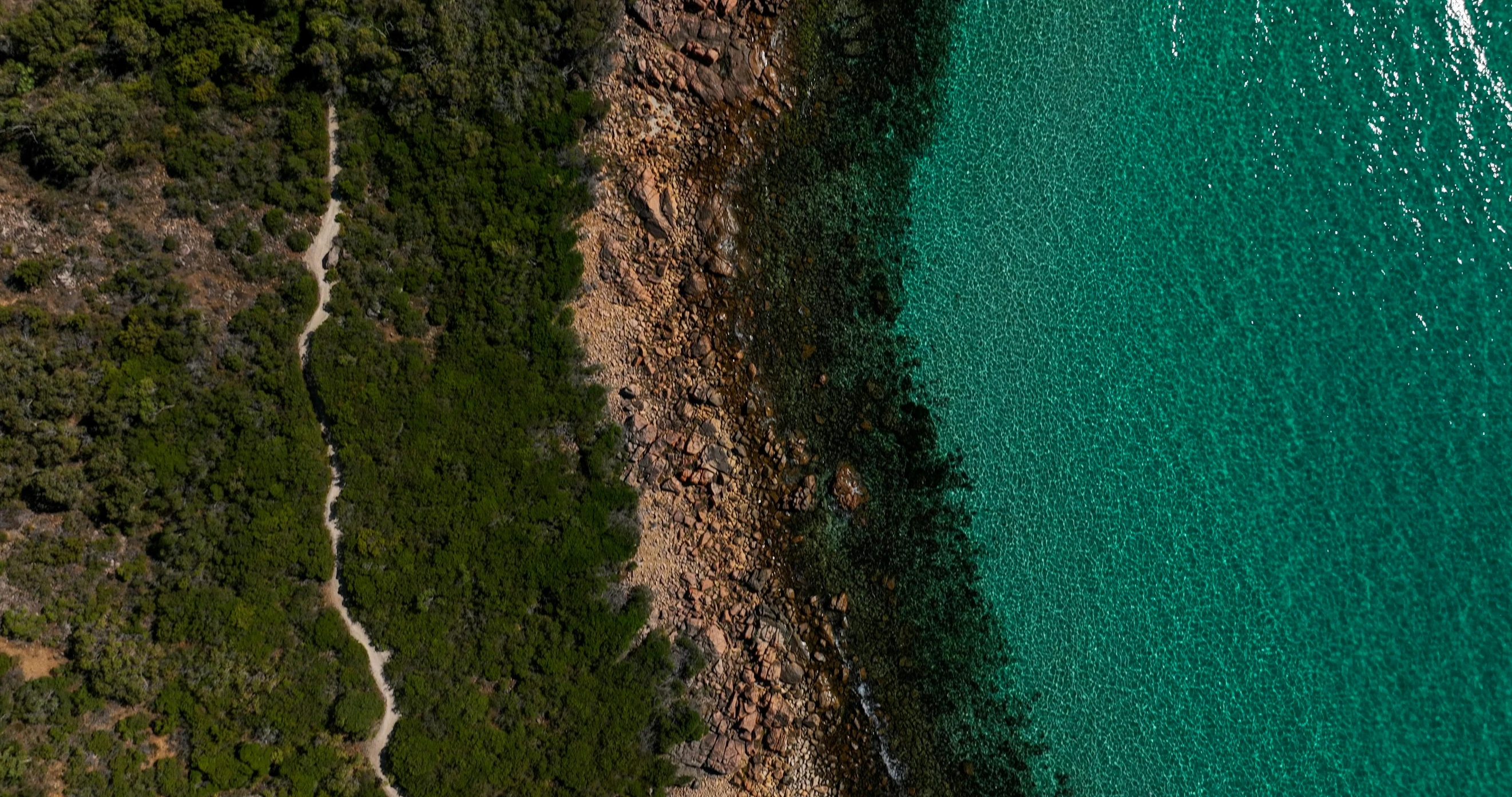 an aerial view of a large body of water, by Peter Churcher, pexels contest winner, rocky ground with a dirt path, the emerald coast, lachlan bailey, depth details