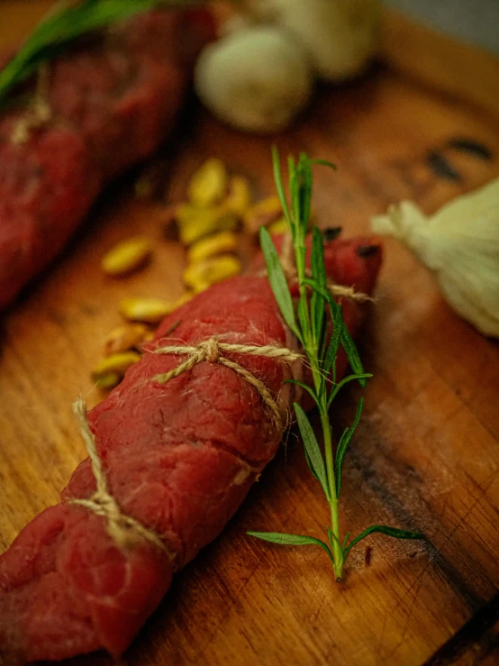 a piece of meat sitting on top of a wooden cutting board, alessio albi, herbs, multiple stories, medium close shot